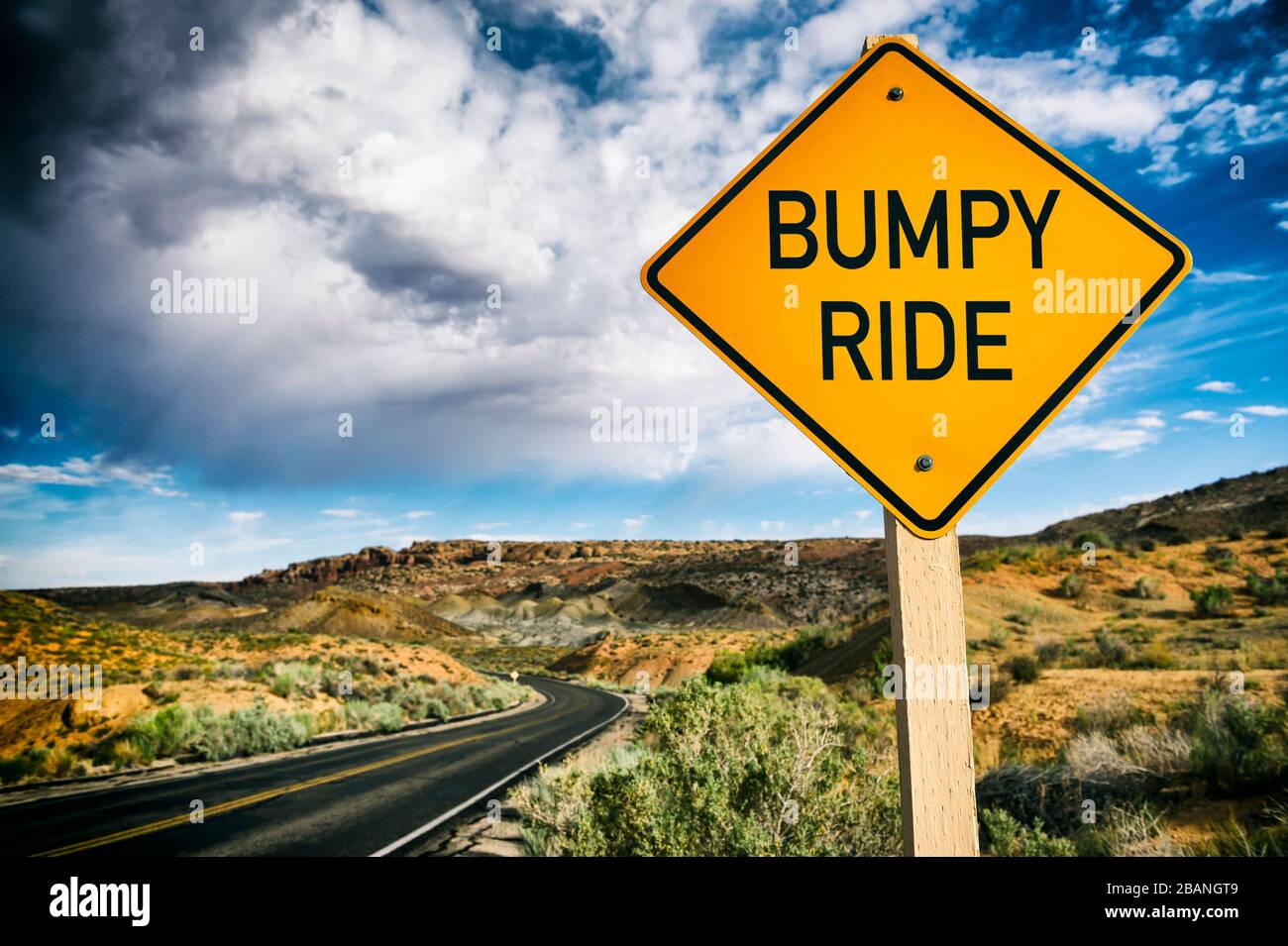 Segnale stradale di avvertimento su una corsa accidentata avanti su deserta strada panoramica estate deserto Foto Stock