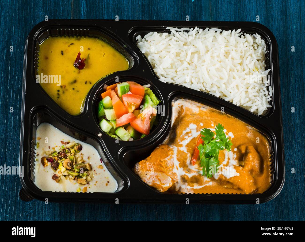 Cibo indiano tra cui curry, riso, samosa e pane naan. Foto Stock