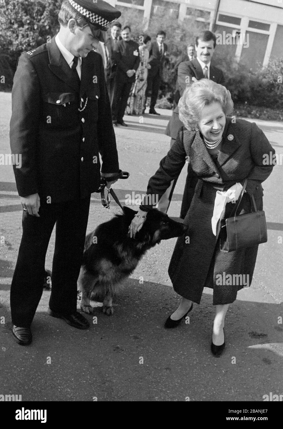 Il primo ministro britannico Margaret Thatcher interagendo con un cane metropolitano di polizia alla sua partenza dall'aeroporto di Heathrow nell'ottobre 1985. Foto Stock