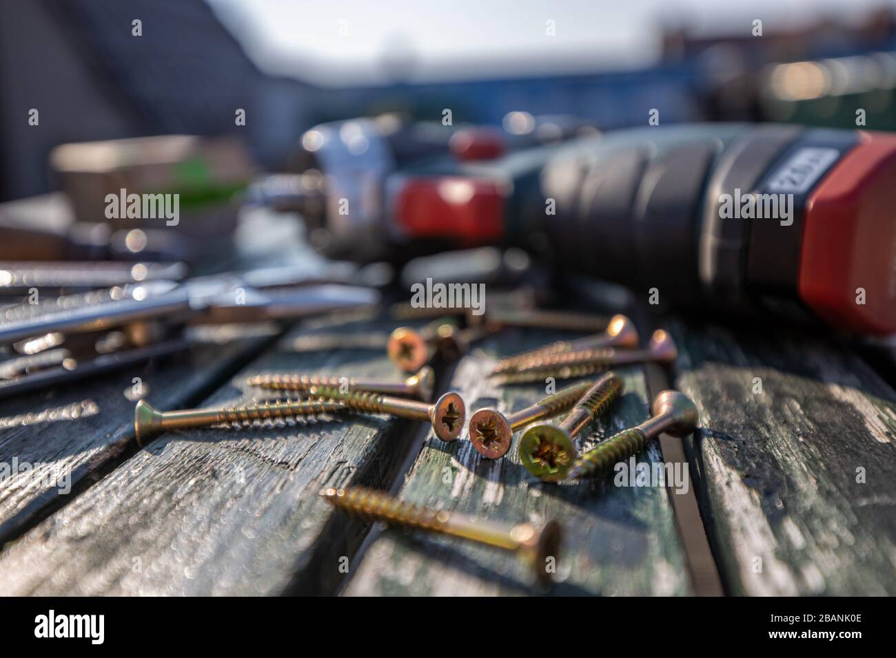 Utensile e vite su una piastra in legno con blur prospettici Foto Stock