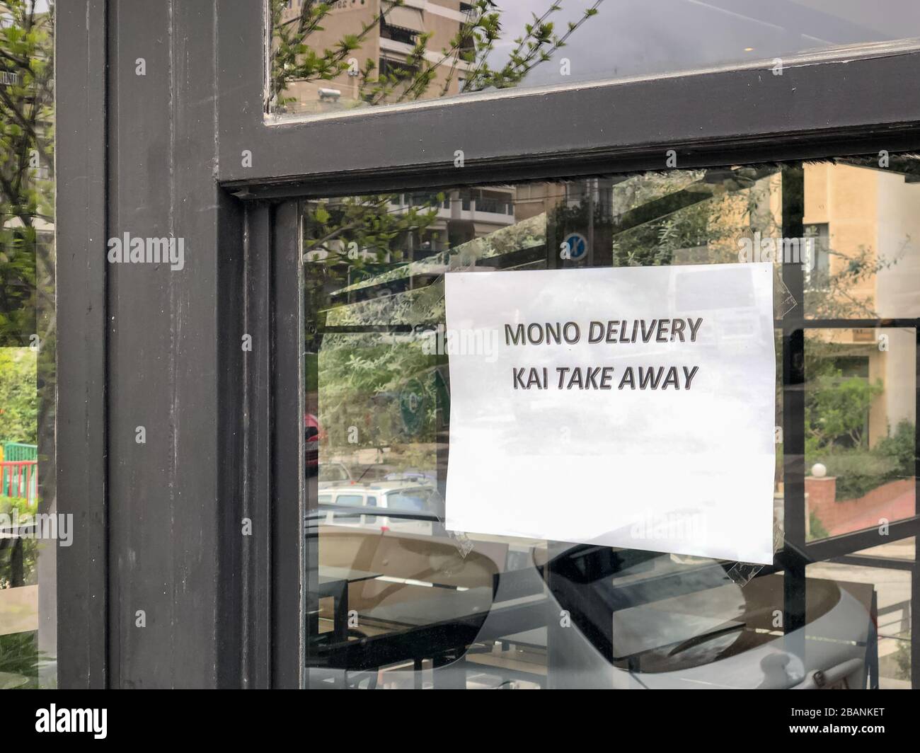 Solo take away e consegna. Il cartello greco si trova alle porte di caffetterie e fast food. Foto Stock