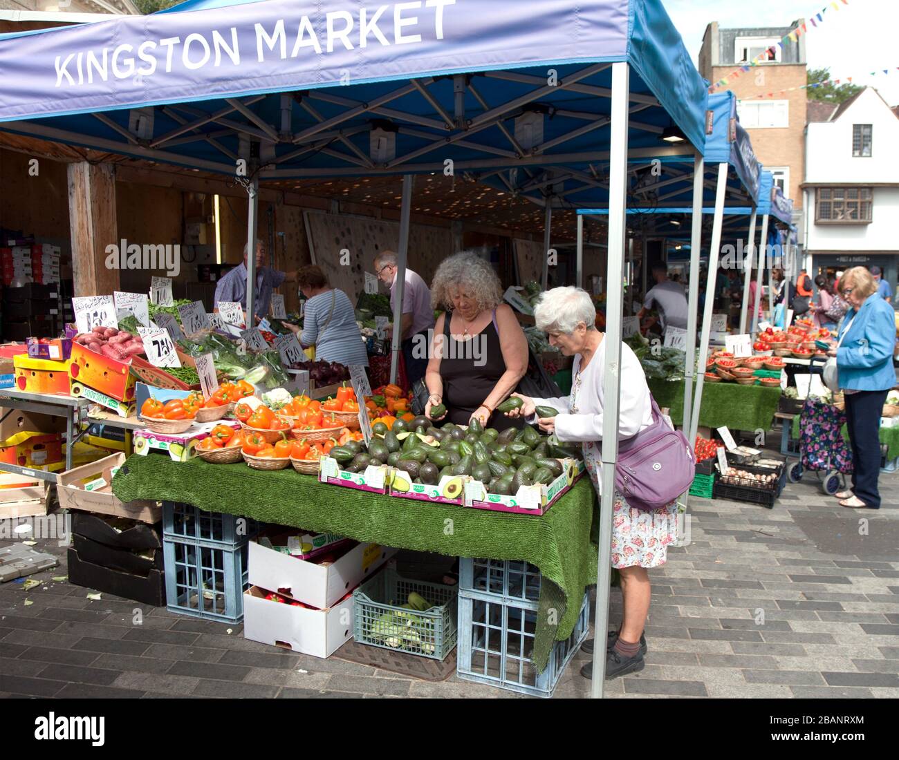 Due donne che selezionano avocados al mercato del mattino. Dal 1242 la gente fa shopping al Kingston's Ancient Marketplace. Foto Stock