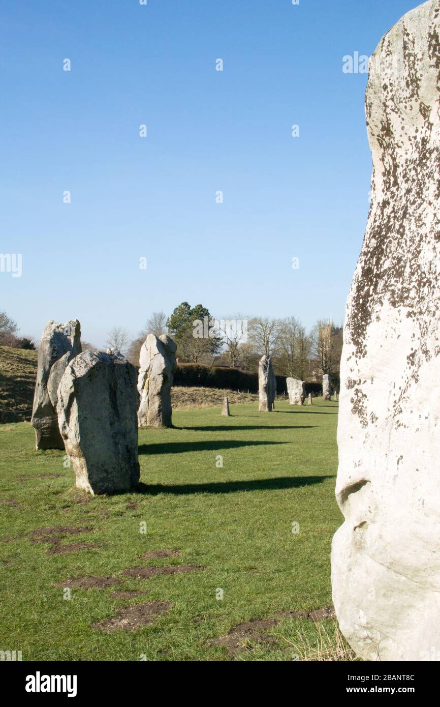 Pietre in piedi che formano il cerchio di pietra neolitico nel villaggio di Avebury, Wiltshire in un giorno di febbraio soleggiato. Foto Stock
