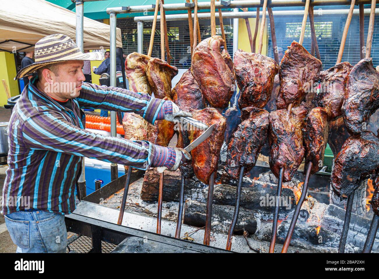 Miami Florida,Little Havana,Calle Ocho Street Festival,celebrazione ispanica,barbeque pit,barbecue,uomo uomini maschio adulti,cuoco,cucina,carne,fuoco,manzo,spi Foto Stock