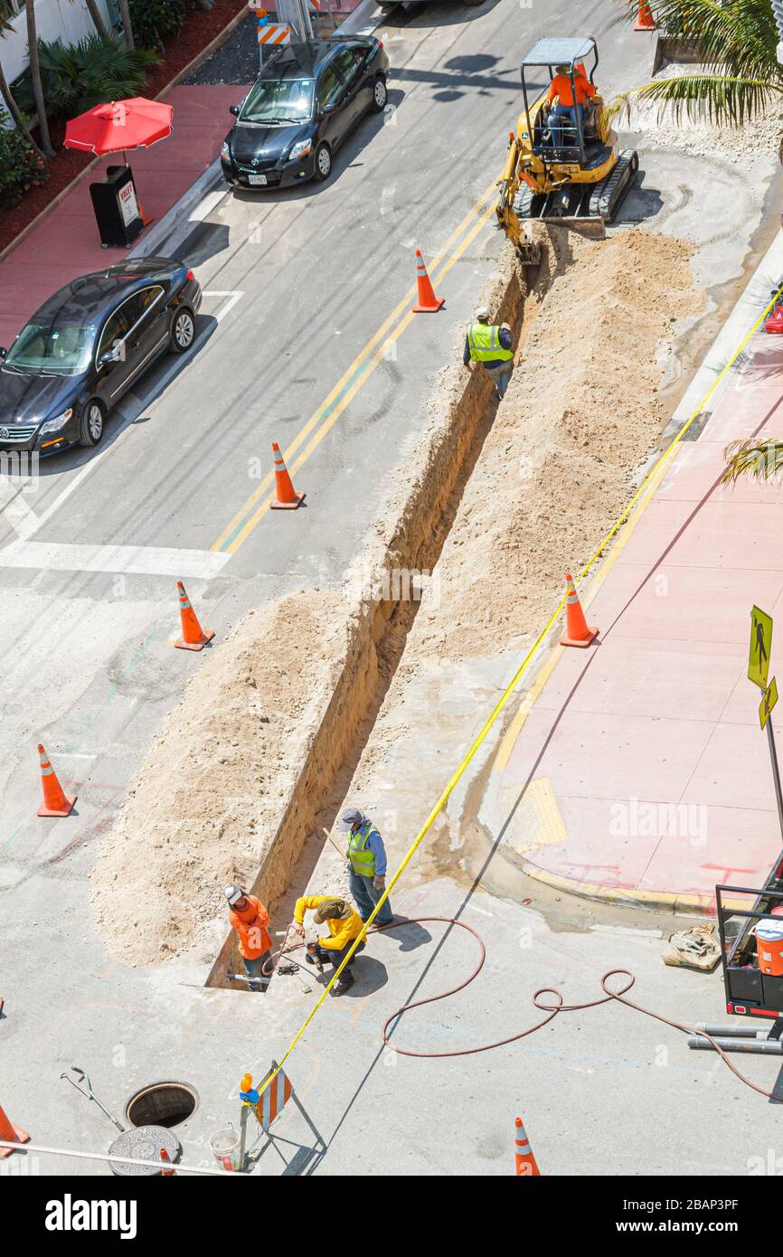 Miami Beach Florida, Ocean Drive, in costruzione nuovo cantiere costruttore, ristrutturazione, riparazione, strada della città, sistema fognario, trattore escavatore, uomo uomini maschio Foto Stock