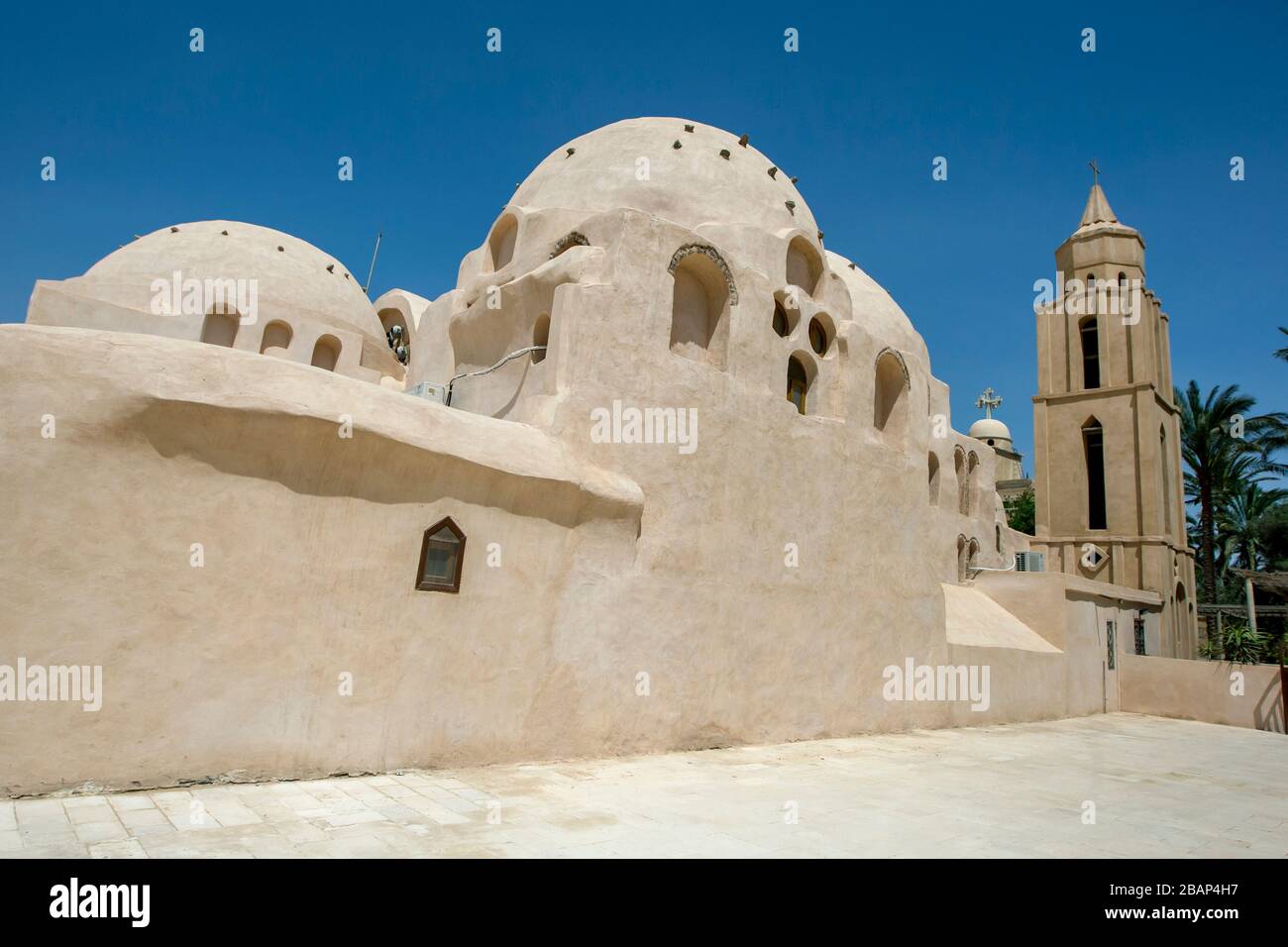 Una torre confina con una sezione a cupola del Monastero di San Bishoy, un monastero ortodosso copto a Wadi El-Natrun in Egitto, fondato nel IV secolo d.C. Foto Stock