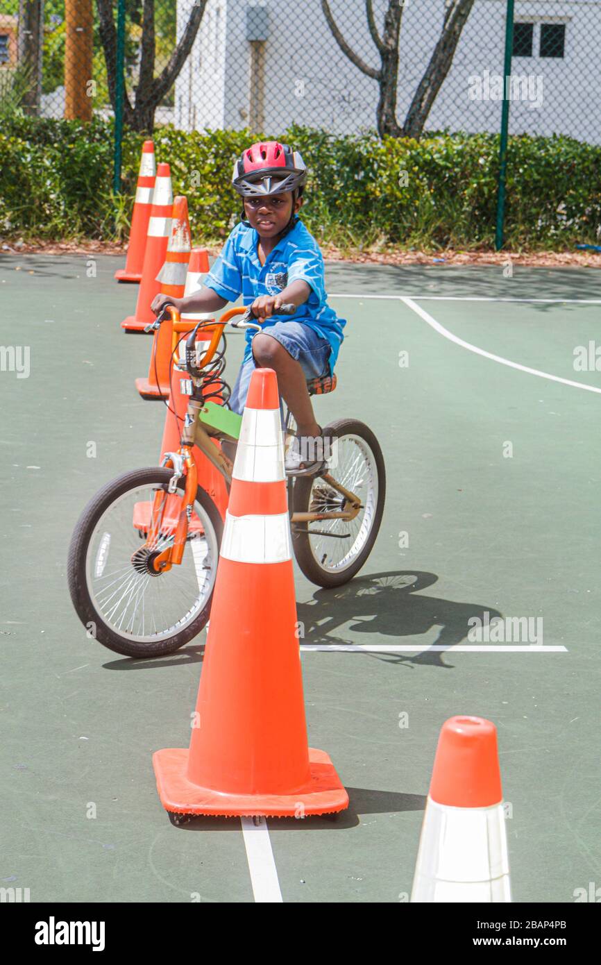 North Miami Beach Florida,Police Community Unit Bicycle Rodeo,cavalcando un ostacolo corso,Orange traffico coni,ragazzi neri,ragazzi maschi bambini bambini Foto Stock