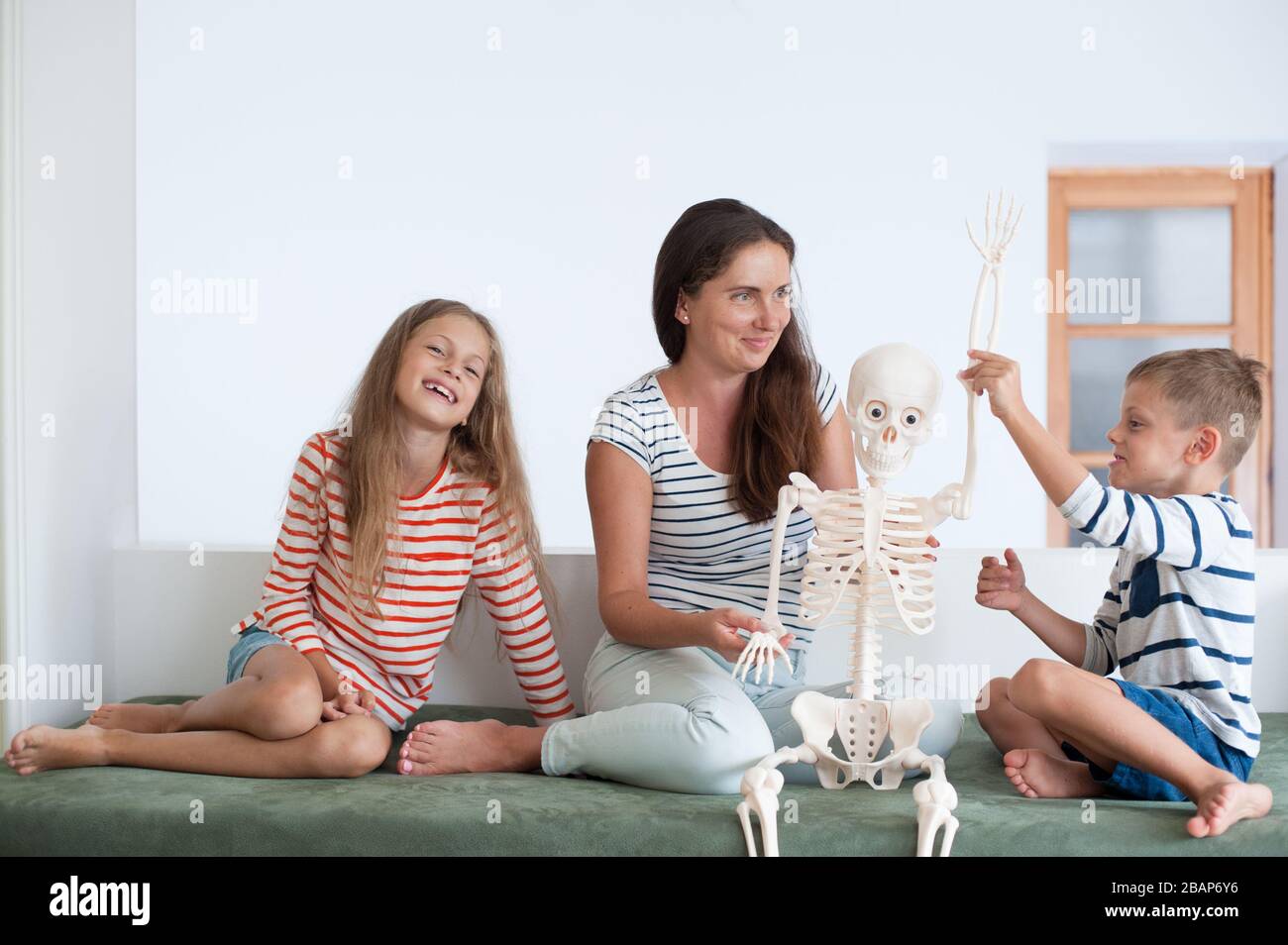 bambino divertente con madre e sorella che gioca famiglia scheletro prank durante la lezione di anatomia Foto Stock