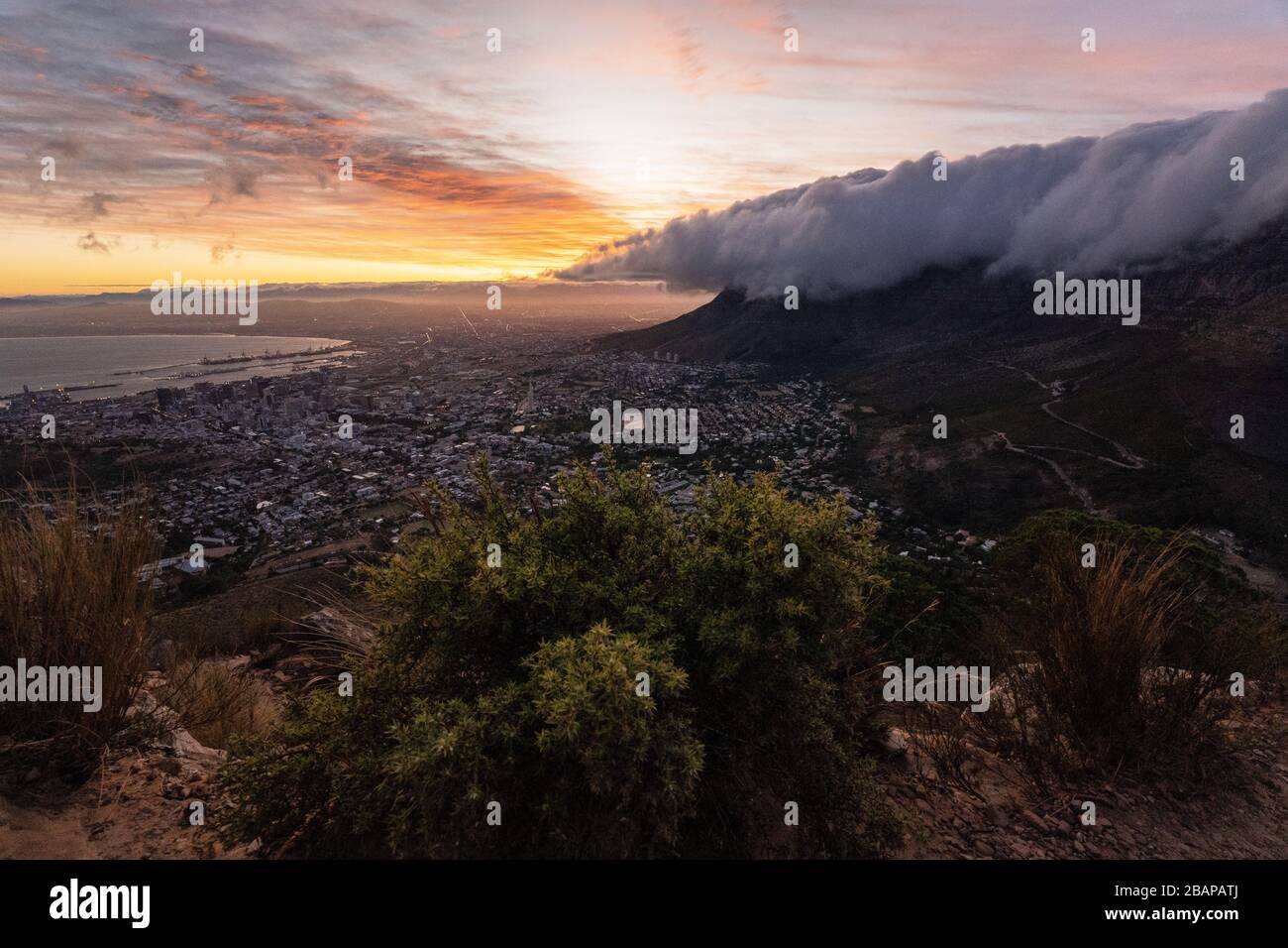 Table Mountain di Città del Capo, tramonto con nuvole sopra la montagna da tavolo, prendendo dalla testa dei leoni Foto Stock