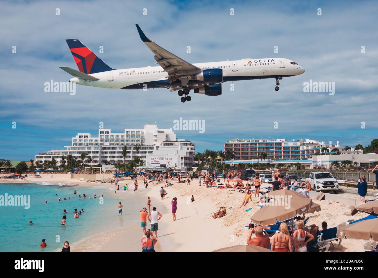 Un Delta Air Lines Boeing 757 vola sopra i turisti sulla spiaggia di Maho mentre atterra a SXM Foto Stock