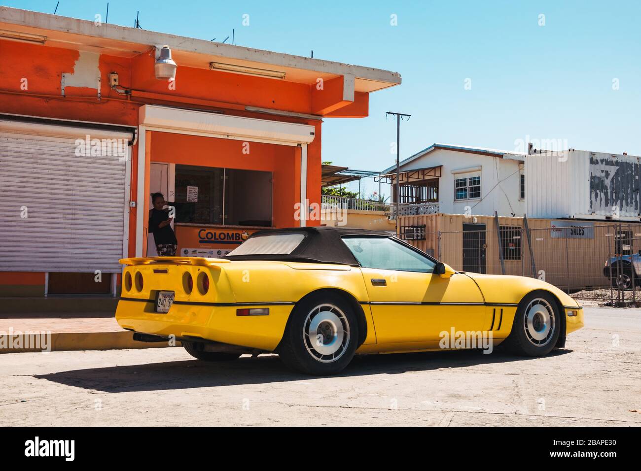 Un vecchio giallo anni '80 Chevrolet Corvette C4 convertibile parcheggiato a Philipsburg, St. Maarten Foto Stock