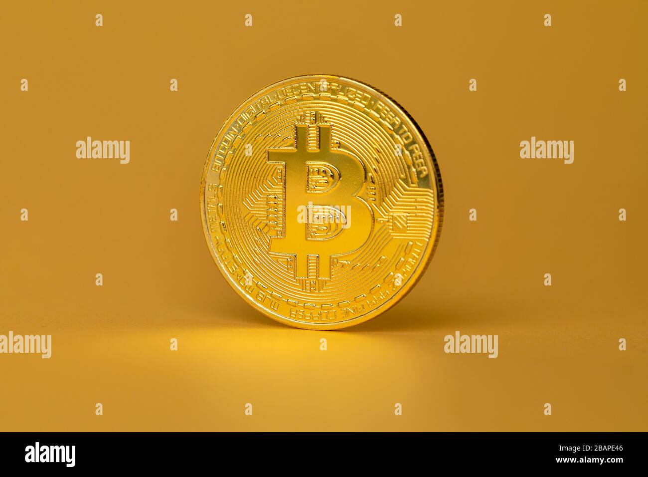 Moneta criptovaluta Bitcoin in piedi su sfondo dorato Foto Stock