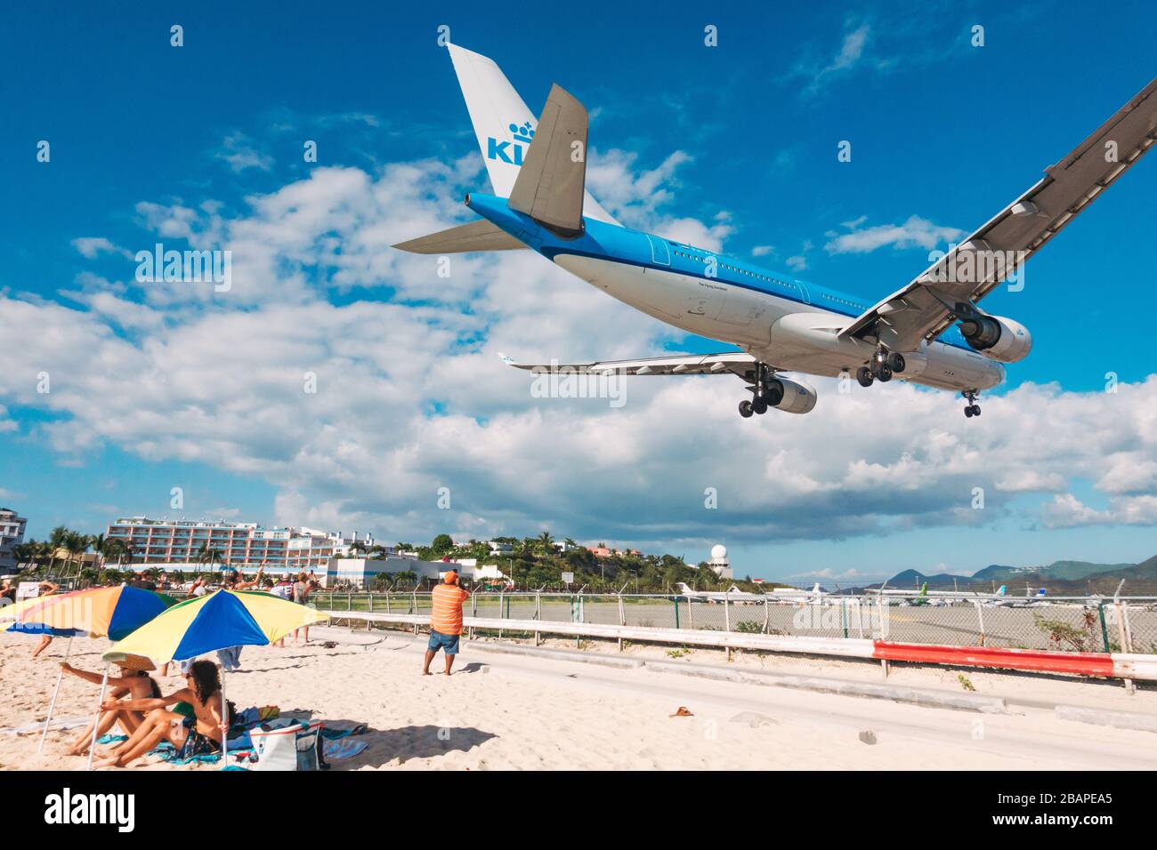Una serie Airbus A330-200 gestita da KLM Royal Dutch Airlines sorvola i turisti sulla spiaggia di Maho, St. Maarten, in avvicinamento all'aeroporto di Princess Juliana Foto Stock