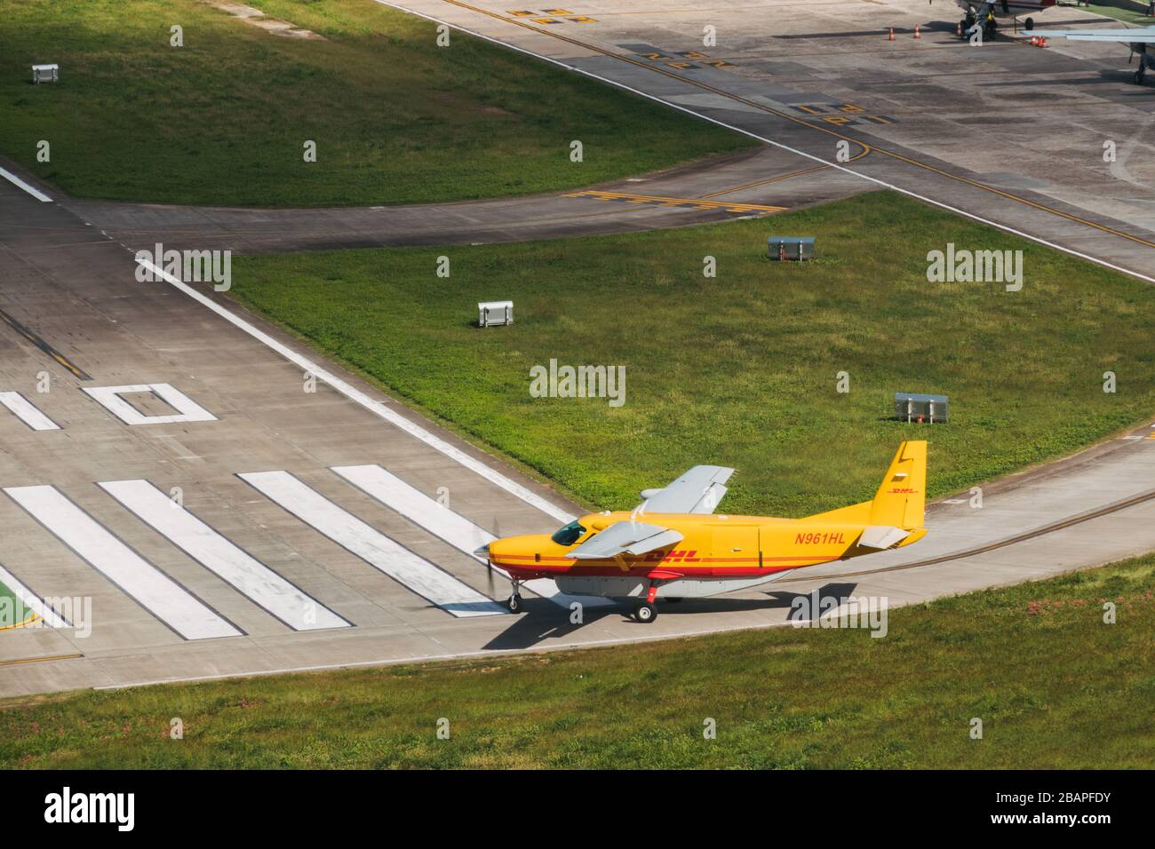 Un aereo da carico DHL Aviation Cessna C208B parte dall'aeroporto di Saint Barthélemy. I piccoli freighter del turboprop sono tramogge comuni dell'isola nei Caraibi Foto Stock