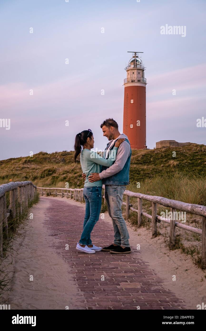 Faro di Texel al tramonto Olanda Isola di Texel, coppia visitare il faro, uomini e donne in vacanza Texel Foto Stock