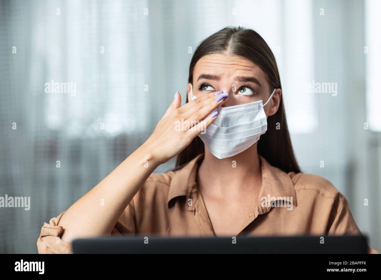 Ritratto di donna in quarantena che indossa la maschera che tocca l'occhio Foto Stock