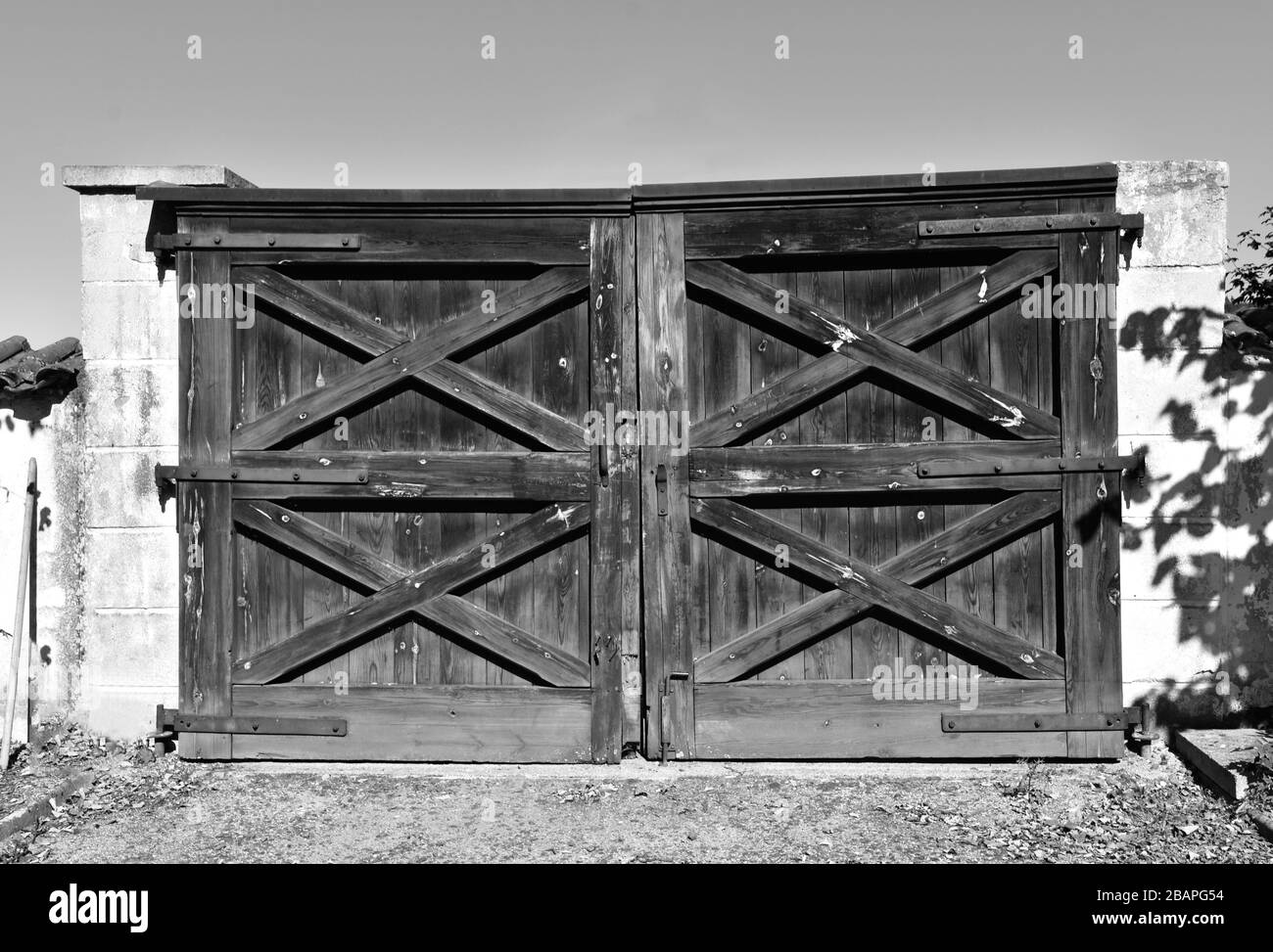 Antica porta di legno di campagna con colonne di pietra in stile vintage in bianco e nero Foto Stock