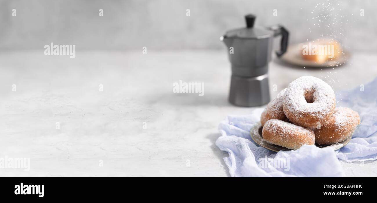 Ciambelle con zucchero in polvere su fondo grigio Foto Stock
