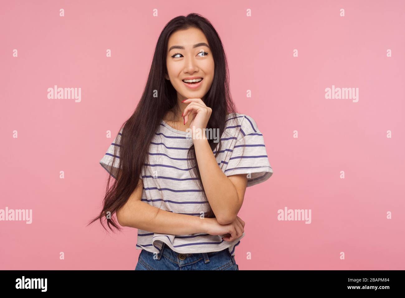 Piacevoli ricordi. Ritratto di ragazza con capelli lunghi in maglietta a righe sorridente e sognante qualcosa di piacevole, ammirando la fantasia, pensando al buon id Foto Stock