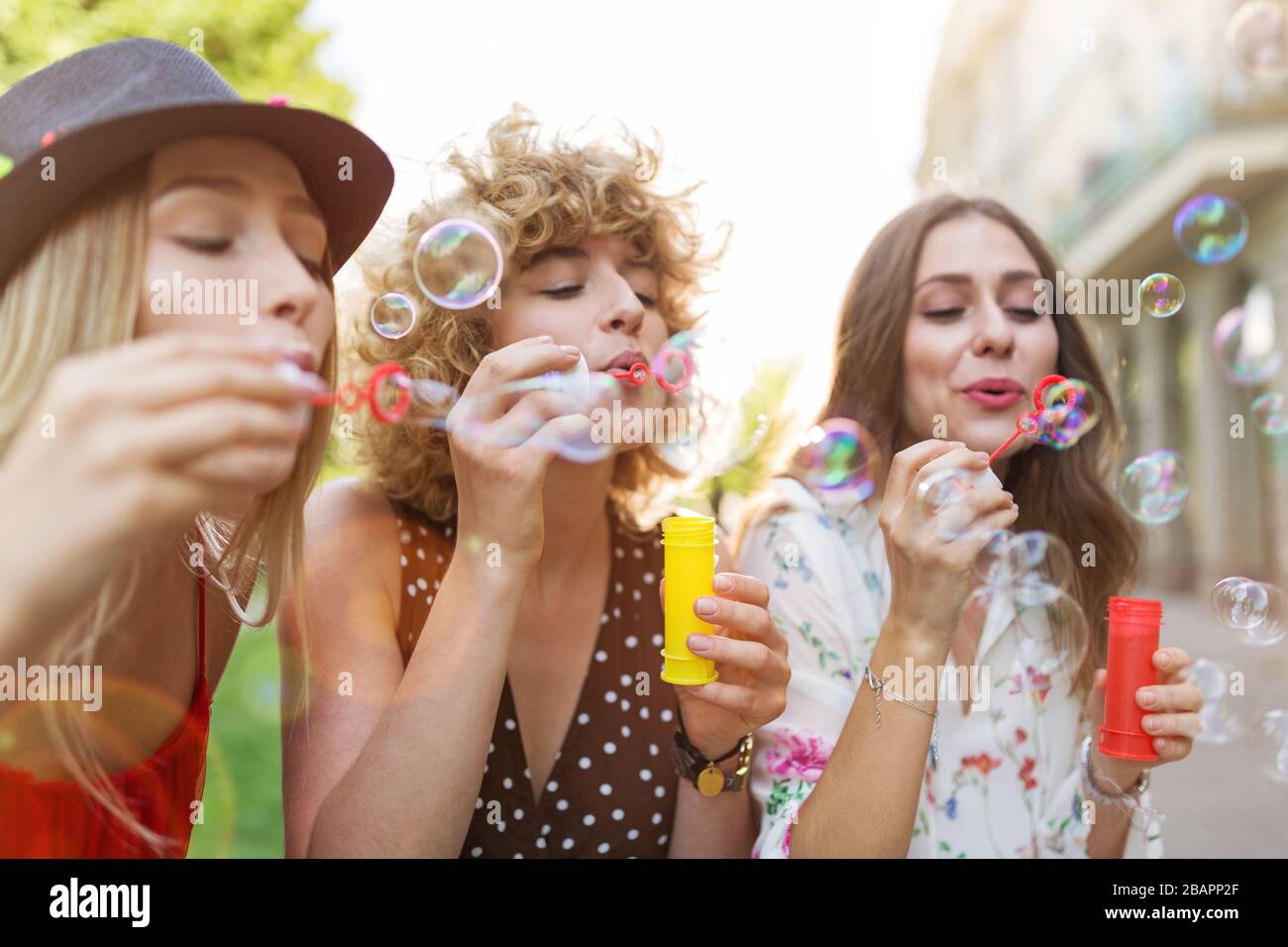 Giovani donne che soffiano bolle di sapone all'aperto Foto Stock