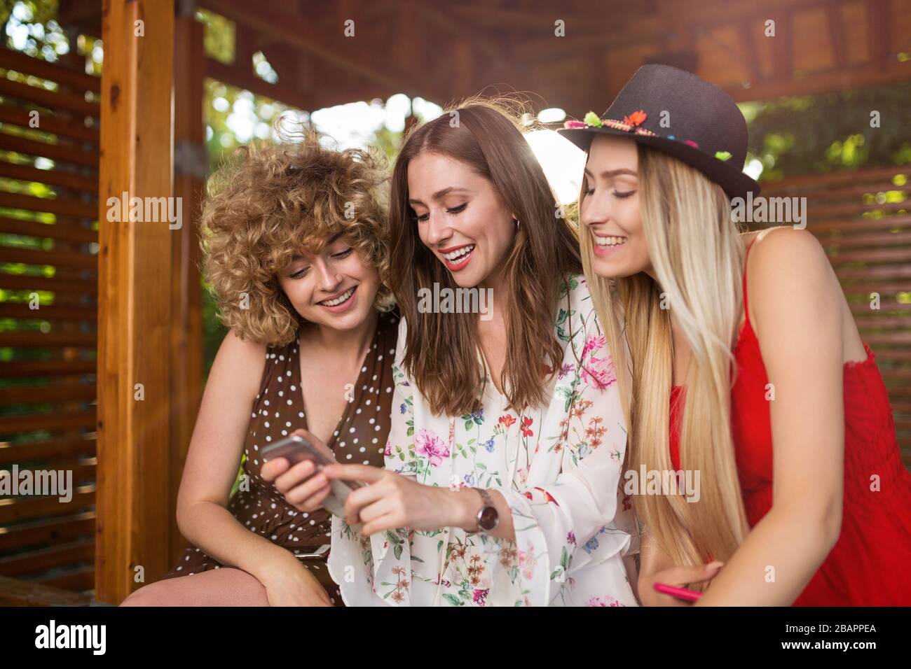 Tre giovani donne felici che si divertono con lo smartphone Foto Stock
