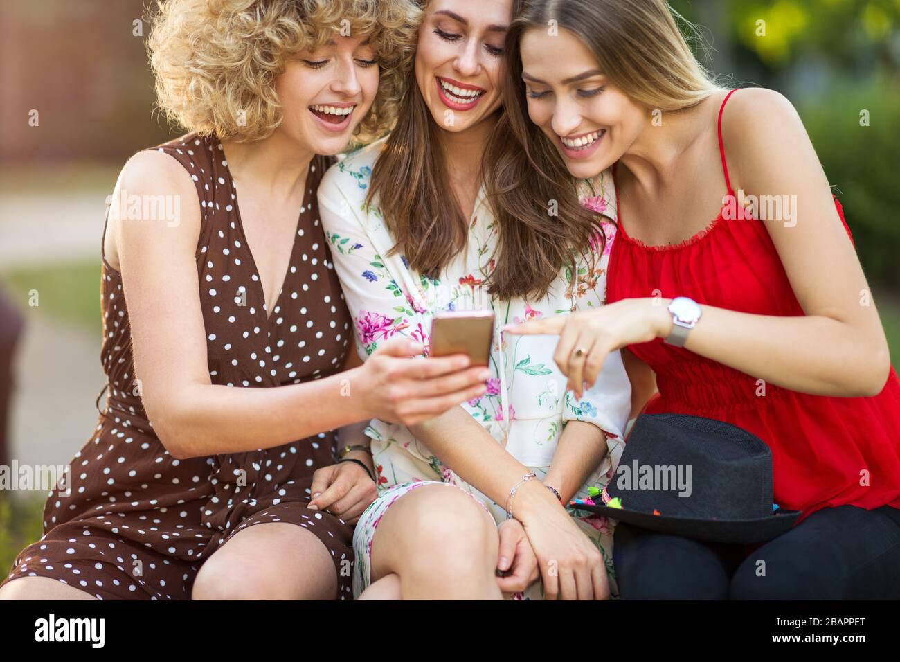 Tre giovani donne felici che si divertono con lo smartphone Foto Stock