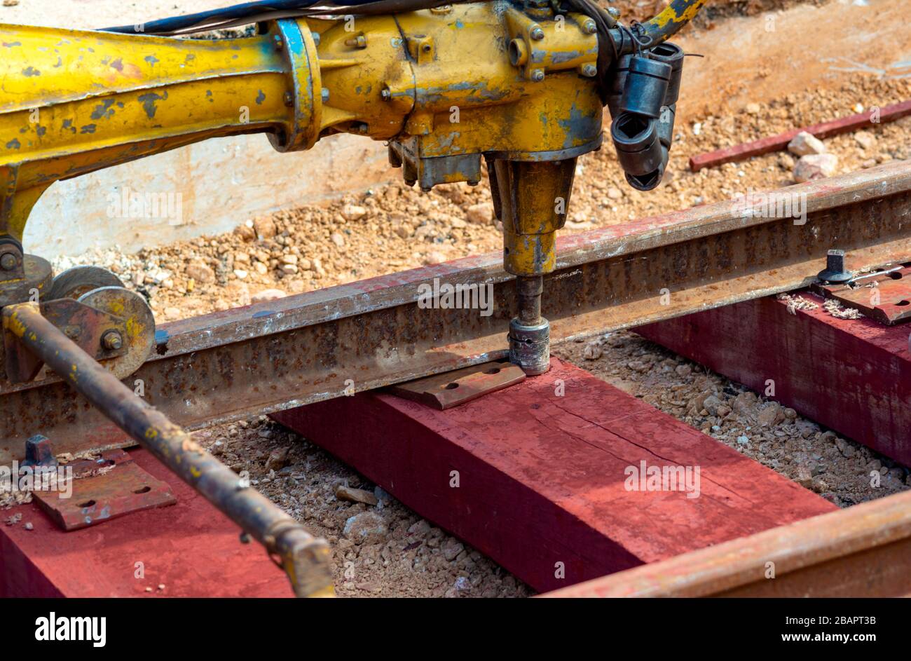 Lavoratori ferroviari che bullonano la ferrovia a binario. Operatore di dettaglio con chiave per bullonatura meccanica Foto Stock