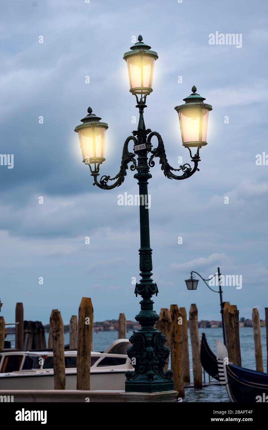 Autentica lanterna di strada rosa di Venezia con i piccioni di Venezia, Italia Foto Stock