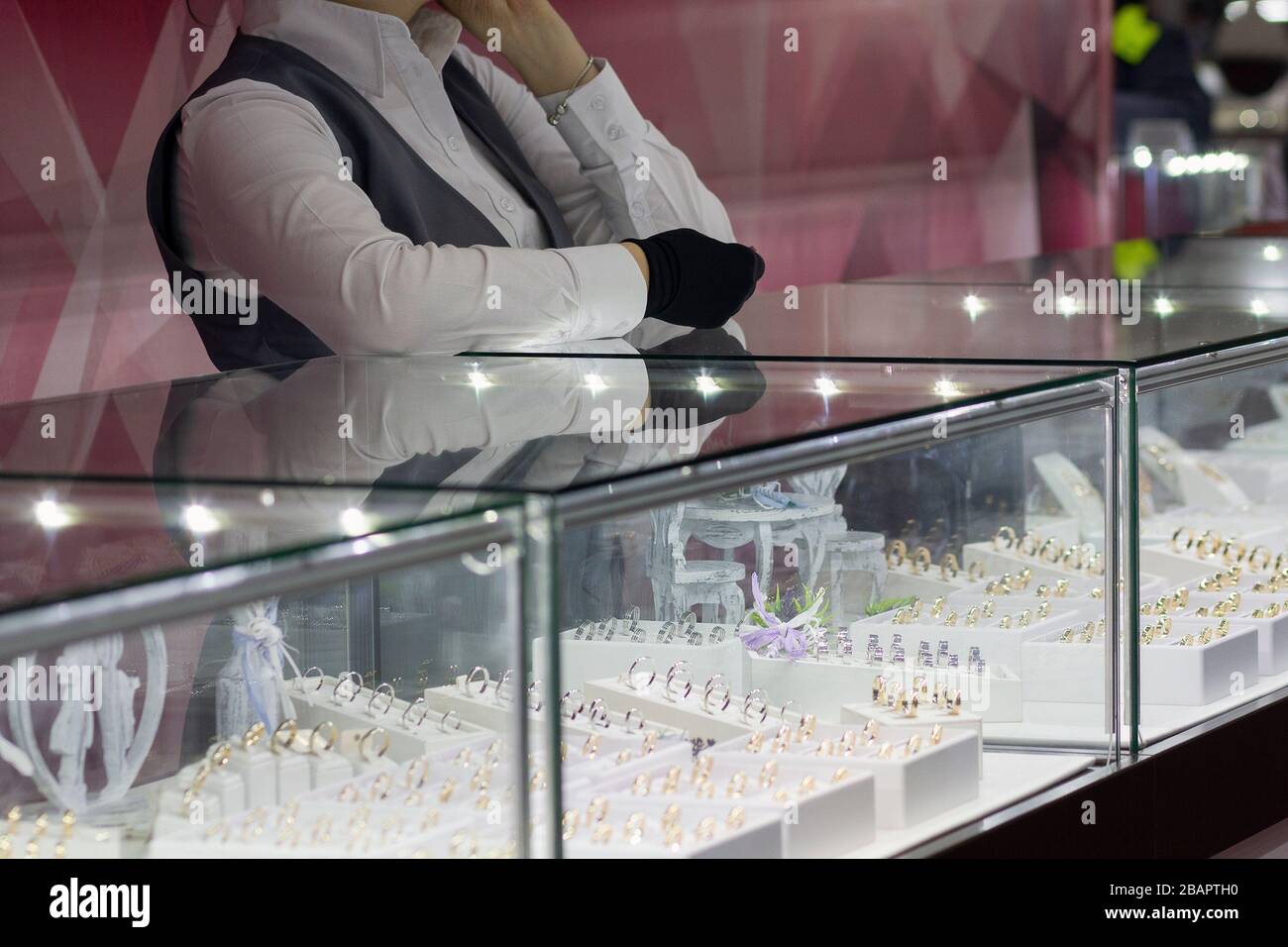 Ragazza vicino a un venditore di banco in un negozio di gioielli. Vendita Foto Stock