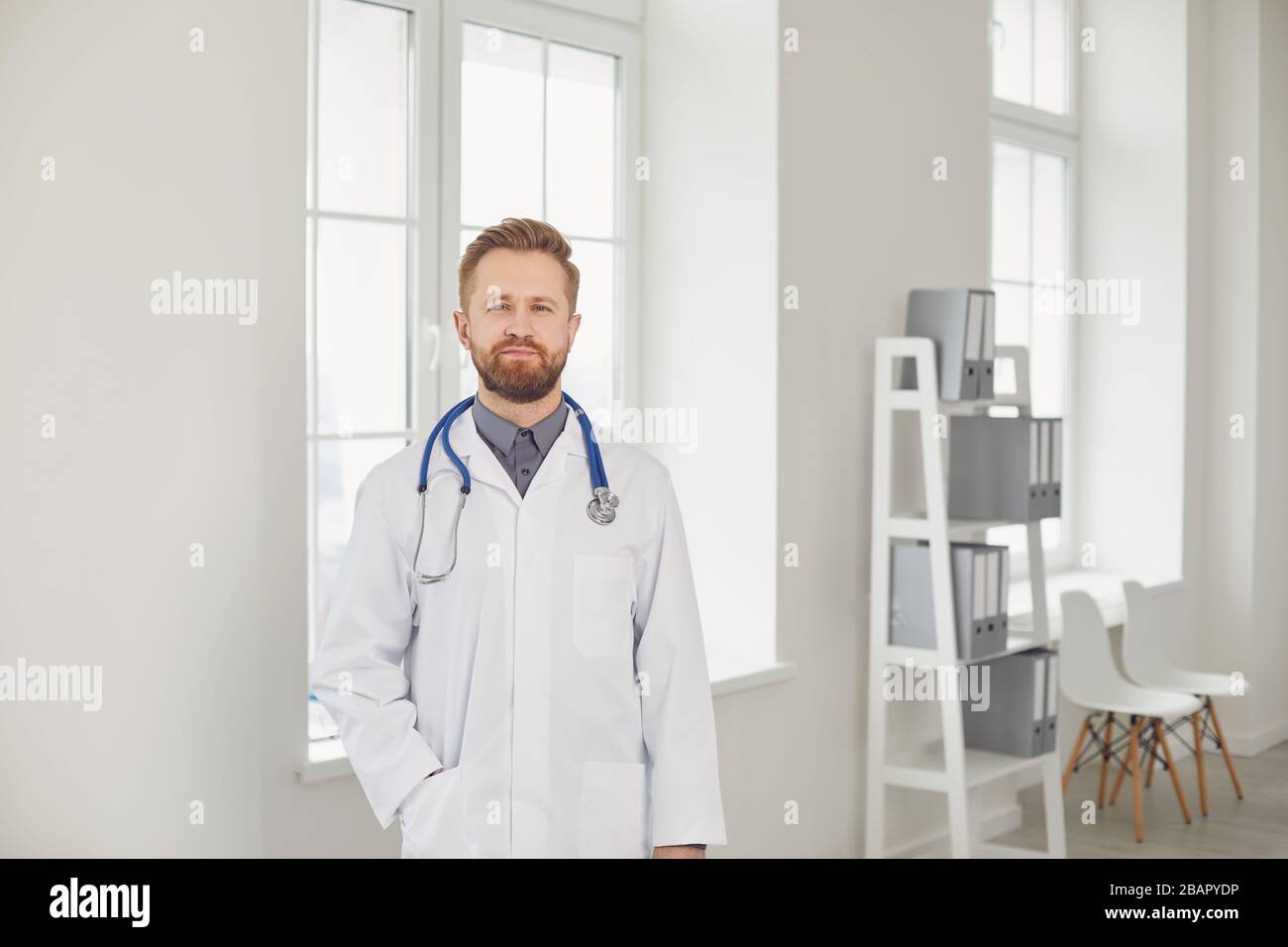 Medico maschile pediatra in piedi nel bianco ufficio dell'ospedale. Foto Stock