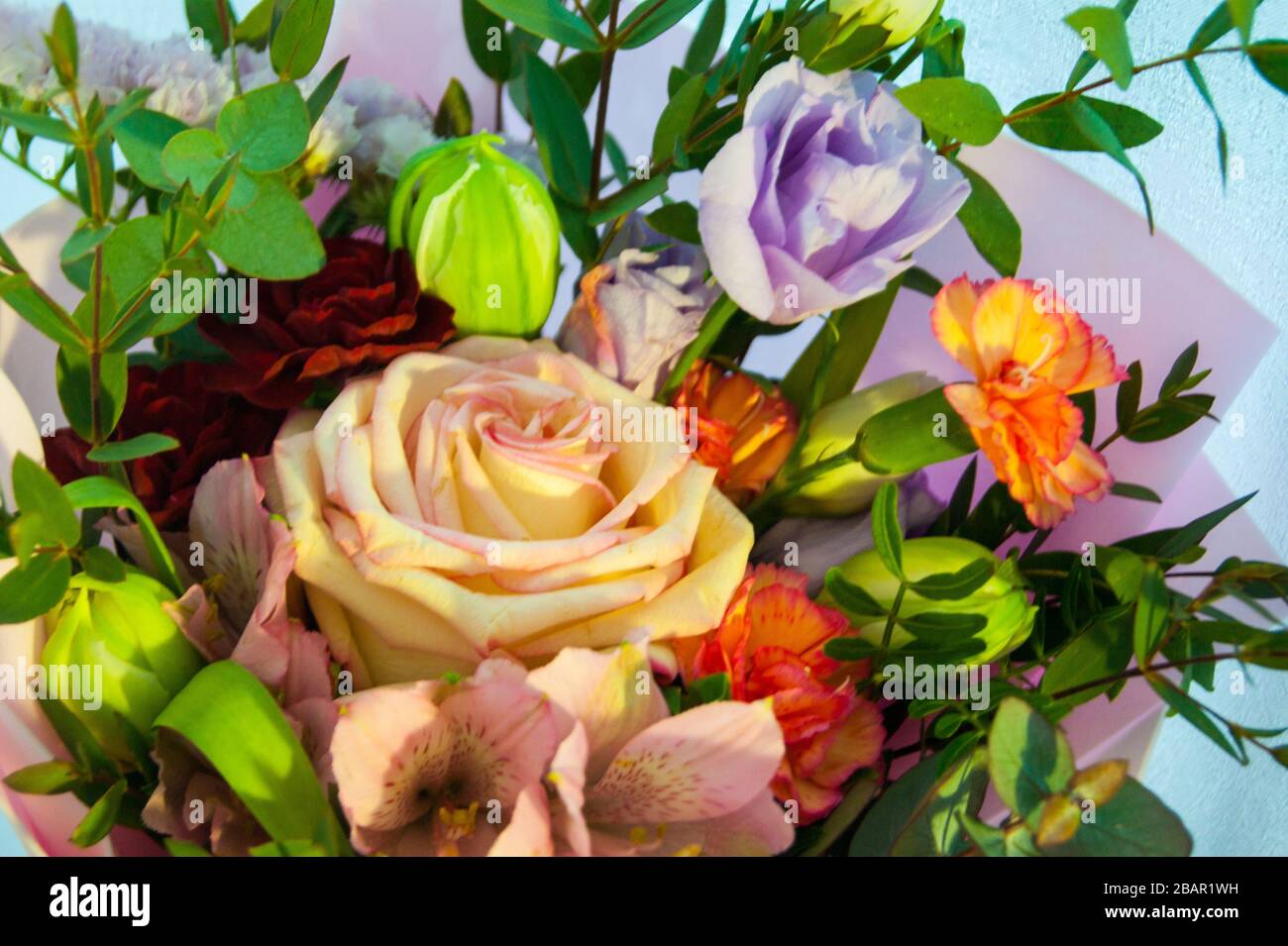 Delicato bouquet di fiori diversi in confezione rosa. Foto orizzontale ravvicinata. Foto Stock