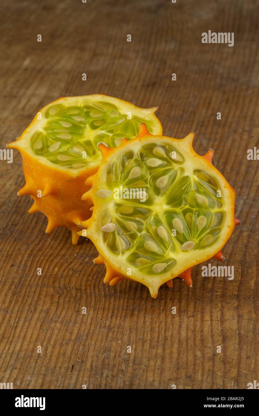 dimezzato frutto melone cornuto isolato su un pannello di legno closeup Foto Stock