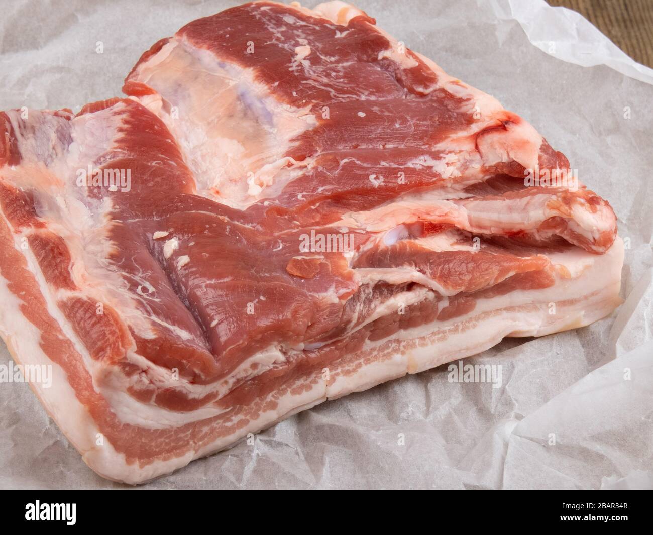 pancia di maiale fresca su carta bianca da imballaggio primo piano Foto Stock