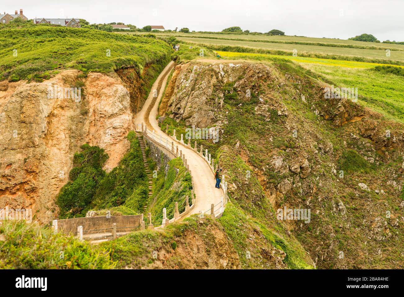 La Coupée, uno stretto istmo di terra tra il Grande Sark e Little Sark (primo piano) nelle Isole del canale del Regno Unito. Strada costruita nel 1945 dai prigionieri tedeschi. Foto Stock