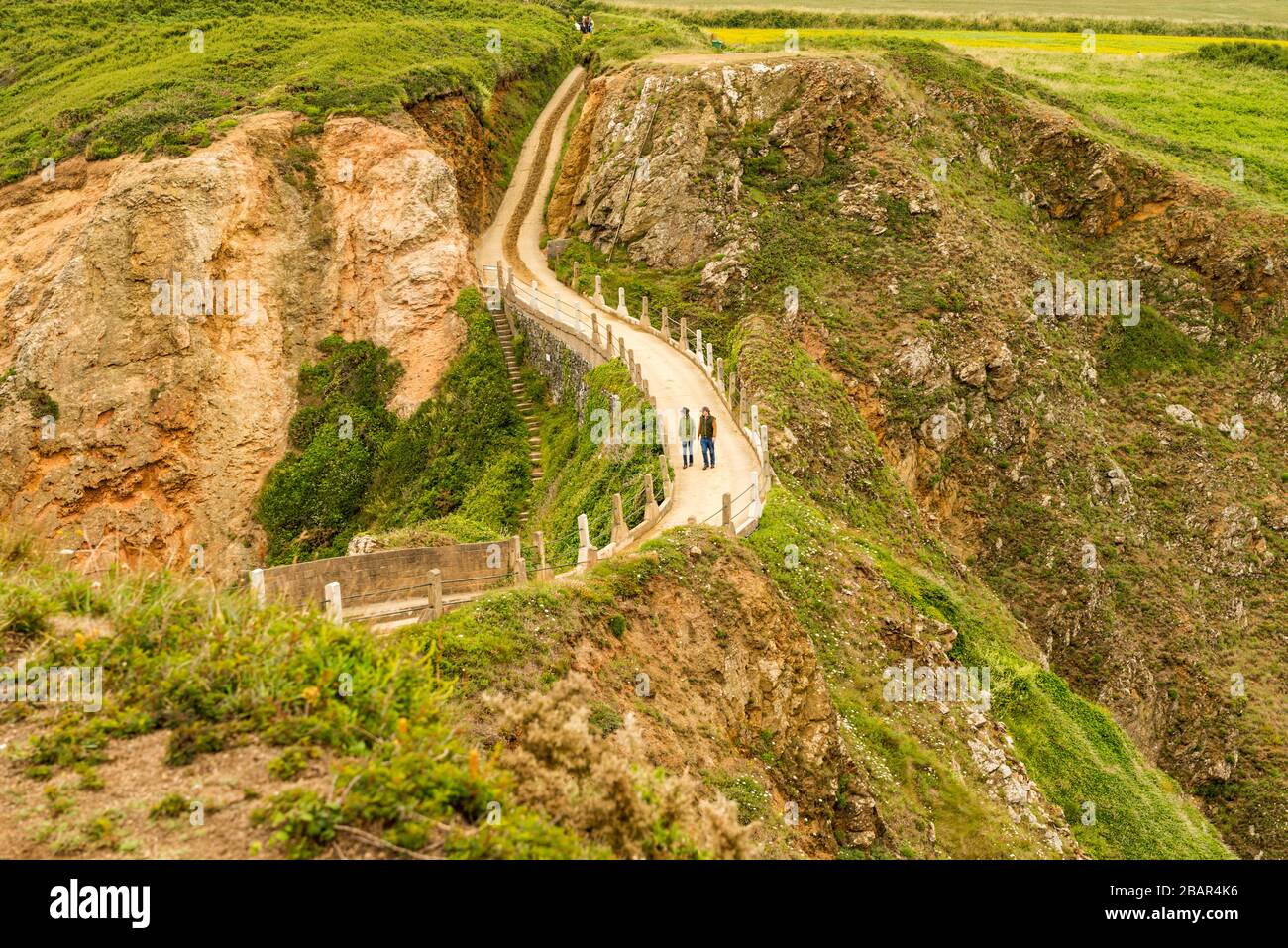 La Coupée, uno stretto istmo di terra tra il Grande Sark e Little Sark (primo piano) nelle Isole del canale del Regno Unito. Strada costruita nel 1945 dai prigionieri tedeschi. Foto Stock