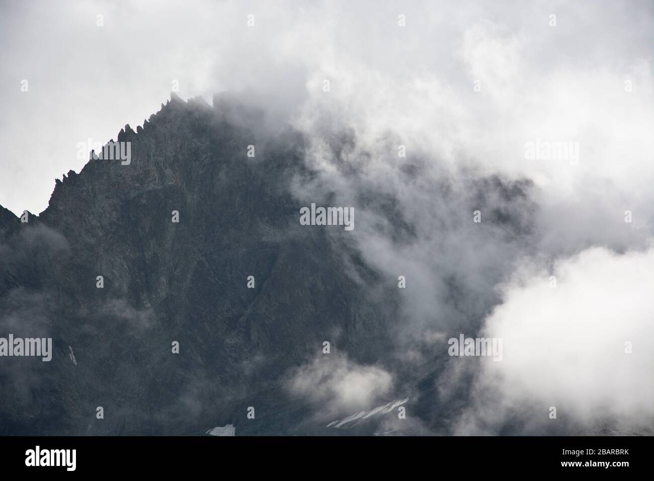 cresta di montagna metà coperta di nuvole in val d'heremence, vallese, svizzera Foto Stock