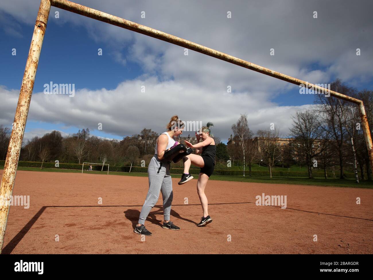 Clementine Sage e Lucy Paterson(L) si esibiscono in Muay Thai nel Kevingrove Park di Glasgow mentre il Regno Unito continua ad essere bloccato per contribuire a frenare la diffusione del coronavirus. Foto Stock