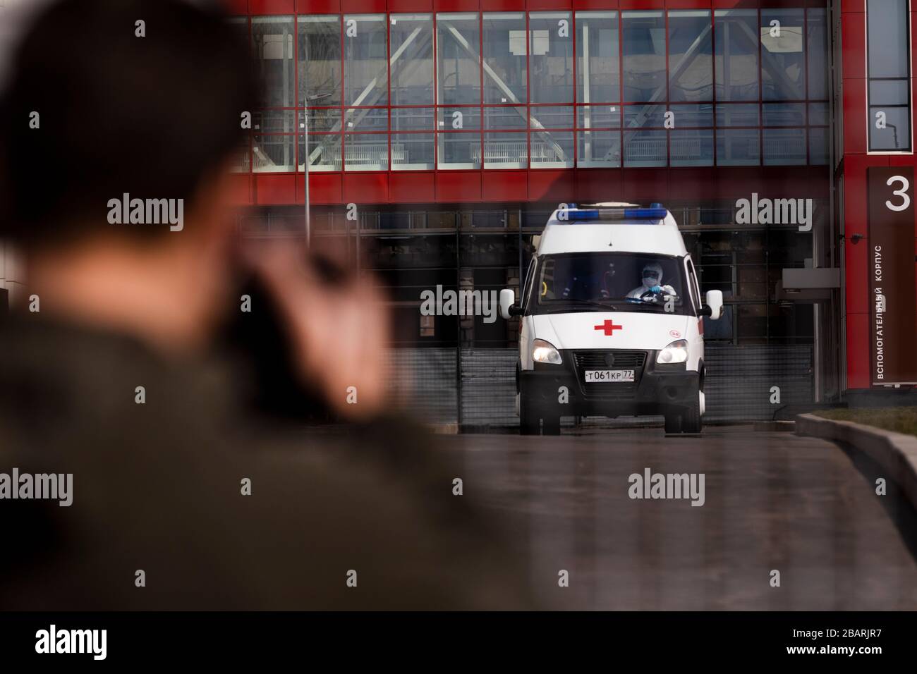 Mosca, Russia. 29 marzo 2020. Un fotografo di un'agenzia di stampa scatta un'auto ambulanza al centro medico specializzato Novomoskovsky di Kommunarka, nel distretto amministrativo di Novomoskovsky, durante la pandemia del COVID-19 Foto Stock