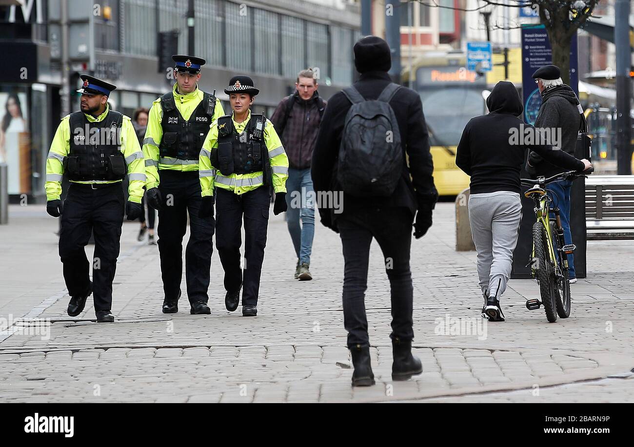 I poliziotti camminano lungo Market Street, Manchester, mentre il Regno Unito continua a bloccarsi per contribuire a frenare la diffusione del coronavirus. Foto Stock