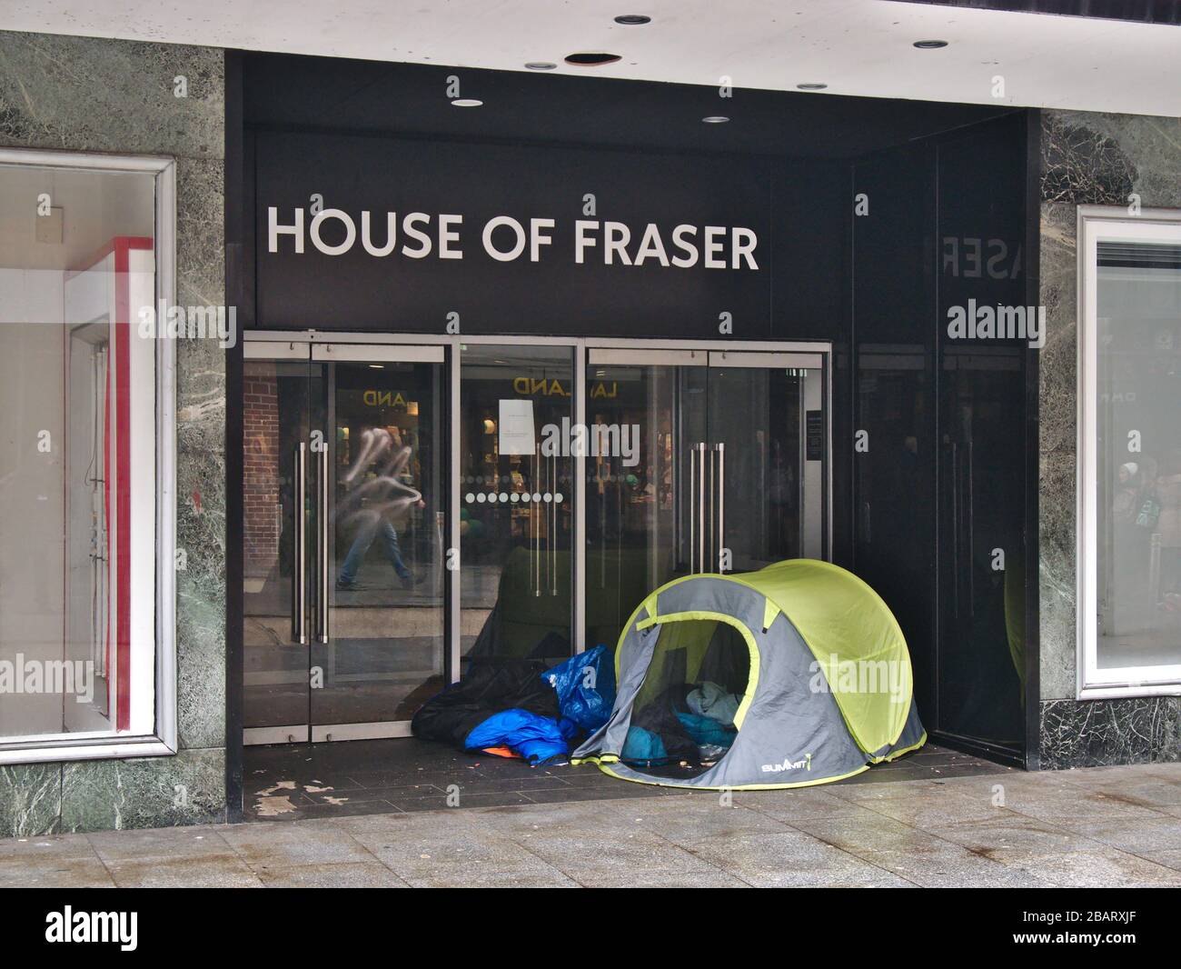 Gli ingressi al ramo chiuso della Casa di Fraser a Exeter sono occupati da alcuni dei senzatetto della città. Foto Stock