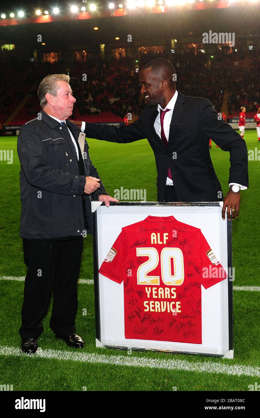 Chris Powell (r), manager atletico di Charlton, presenta una maglietta firmata ad Alf Bloomfield (l) che si ritirò come membro del personale di addestramento del club Foto Stock