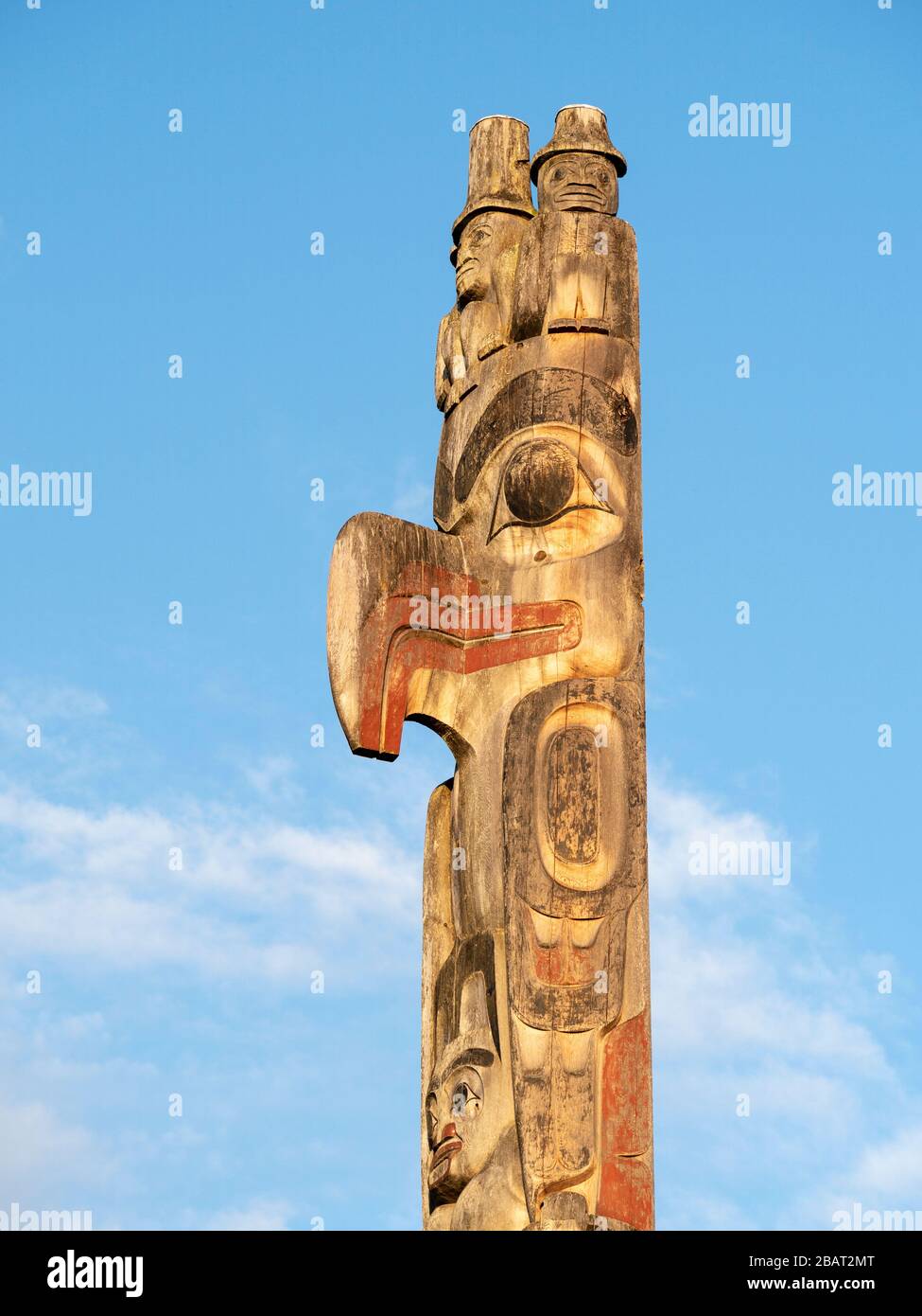 Totem pole al tramonto: La cima di un grande totem scolpito della costa occidentale in mostra al Museo UBC di Antropologia contro un cielo blu. Foto Stock
