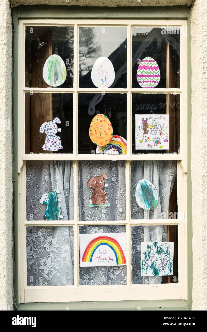 Una finestra decorata con disegni per bambini relativi alla Pasqua e allo scoppio del coronavirus, nella piccola città di Presteigne, Powys, Regno Unito Foto Stock
