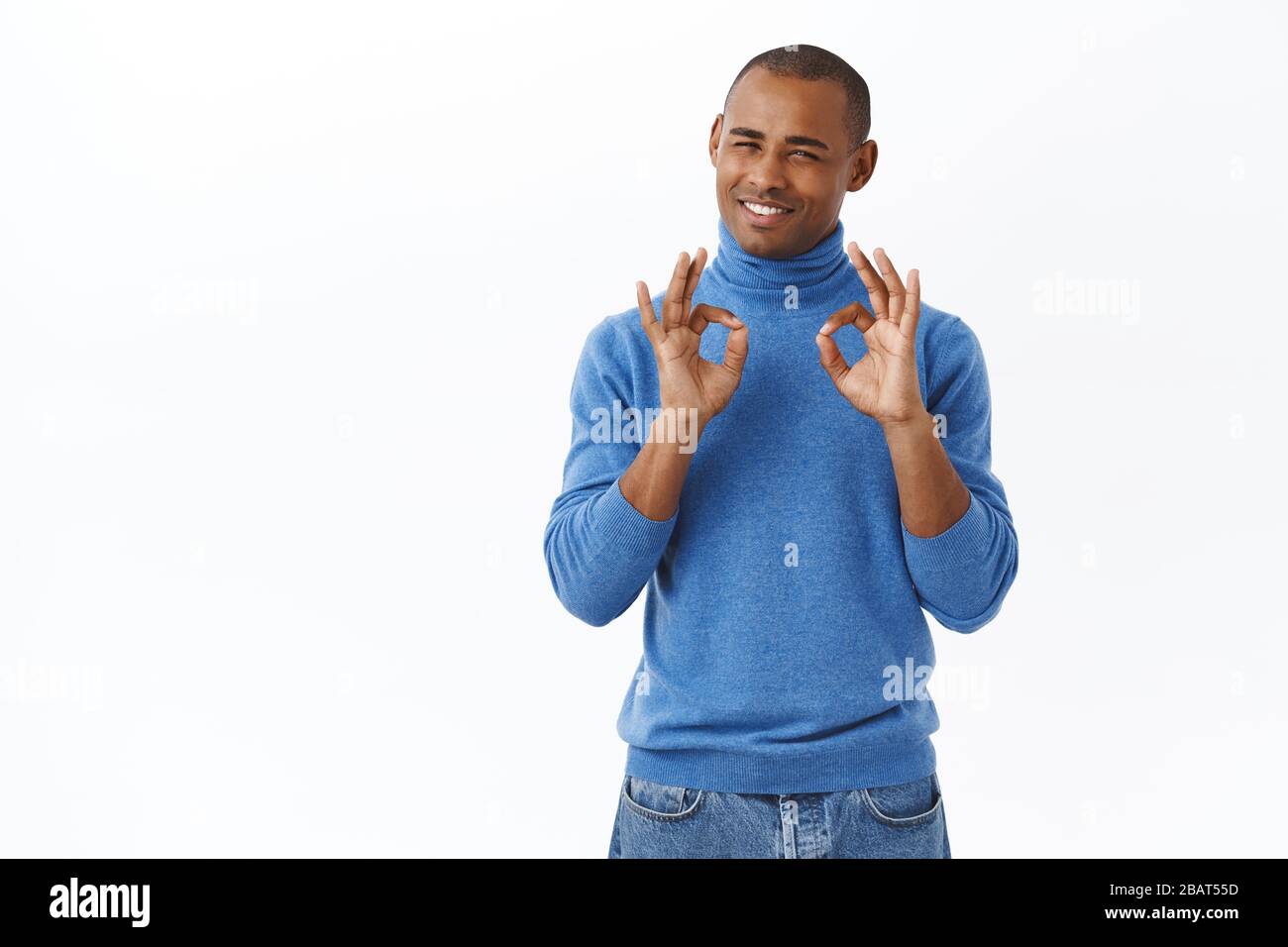 Ritratto di felice bell'uomo afro-americano che mostra segno okay, garantire la migliore qualità, essere soddisfatto con il servizio perfetto, descrivere sorprendente Foto Stock