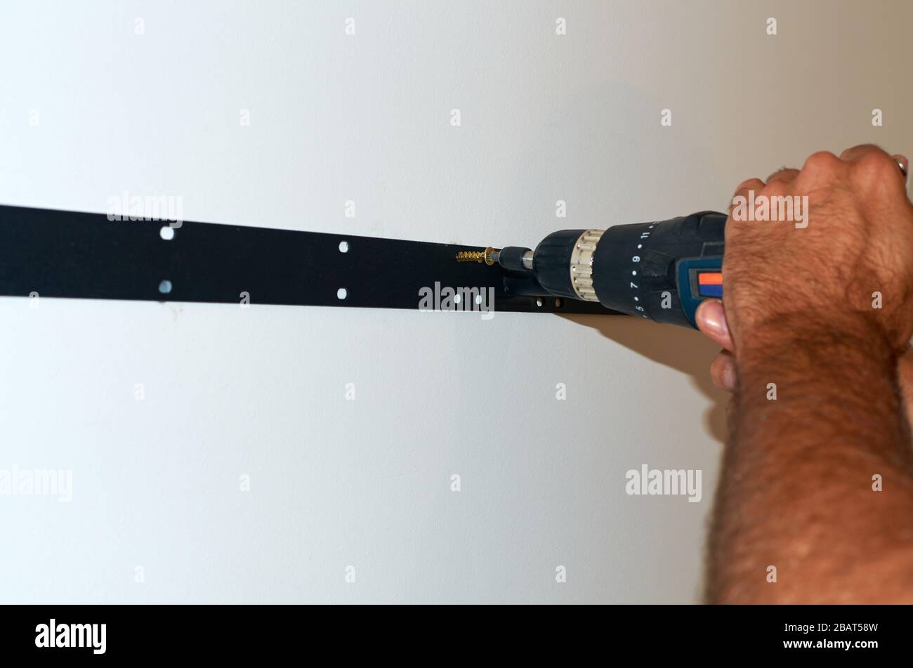 Avvitamento di un supporto a parete - primo piano Foto Stock