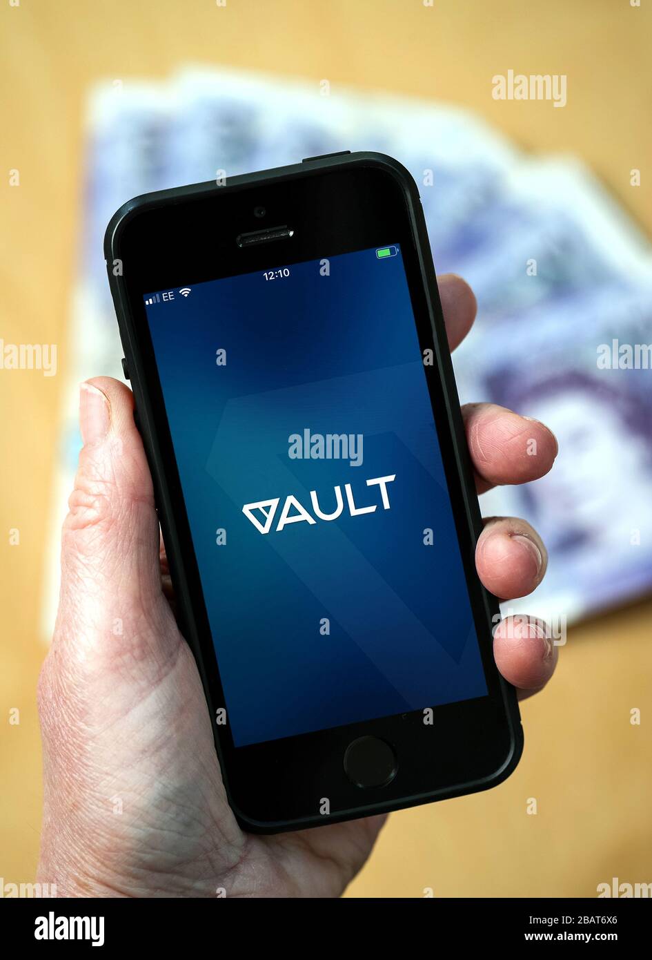 Una donna che utilizza l'app DeVere Vault su un telefono cellulare. (Solo per uso editoriale) Foto Stock
