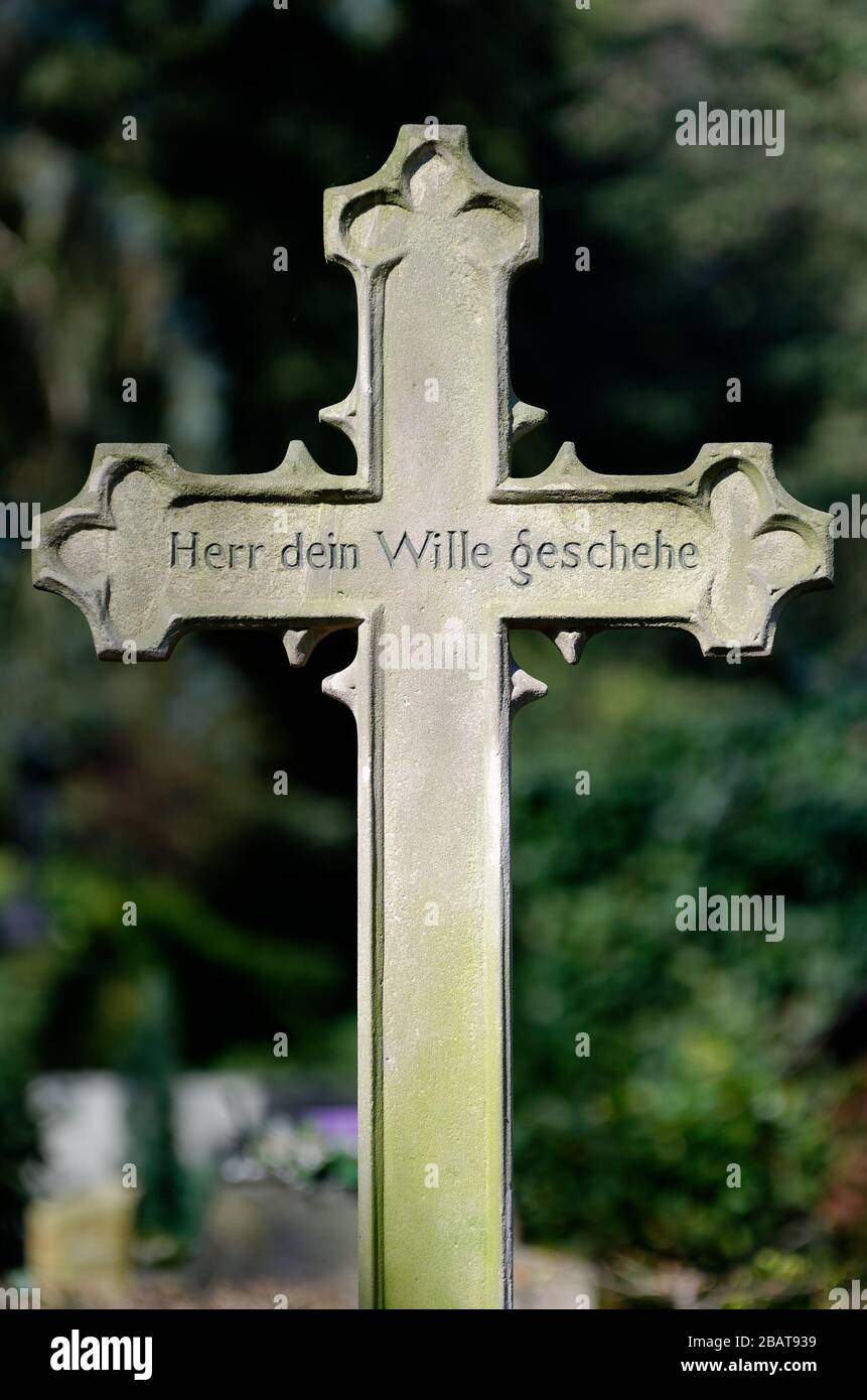 vecchia croce di pietra con la scrittura; signore tua volontà sarà fatto, su una tomba in un cimitero Foto Stock