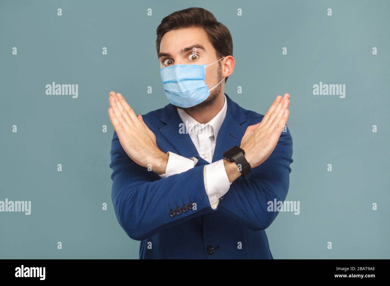 Stop, no! Ritratto di giovane uomo con maschera medica chirurgica in piedi. Mostrando il divieto di mano vicino alla fotocamera. Medicina di gente di affari e concessione di sanità Foto Stock