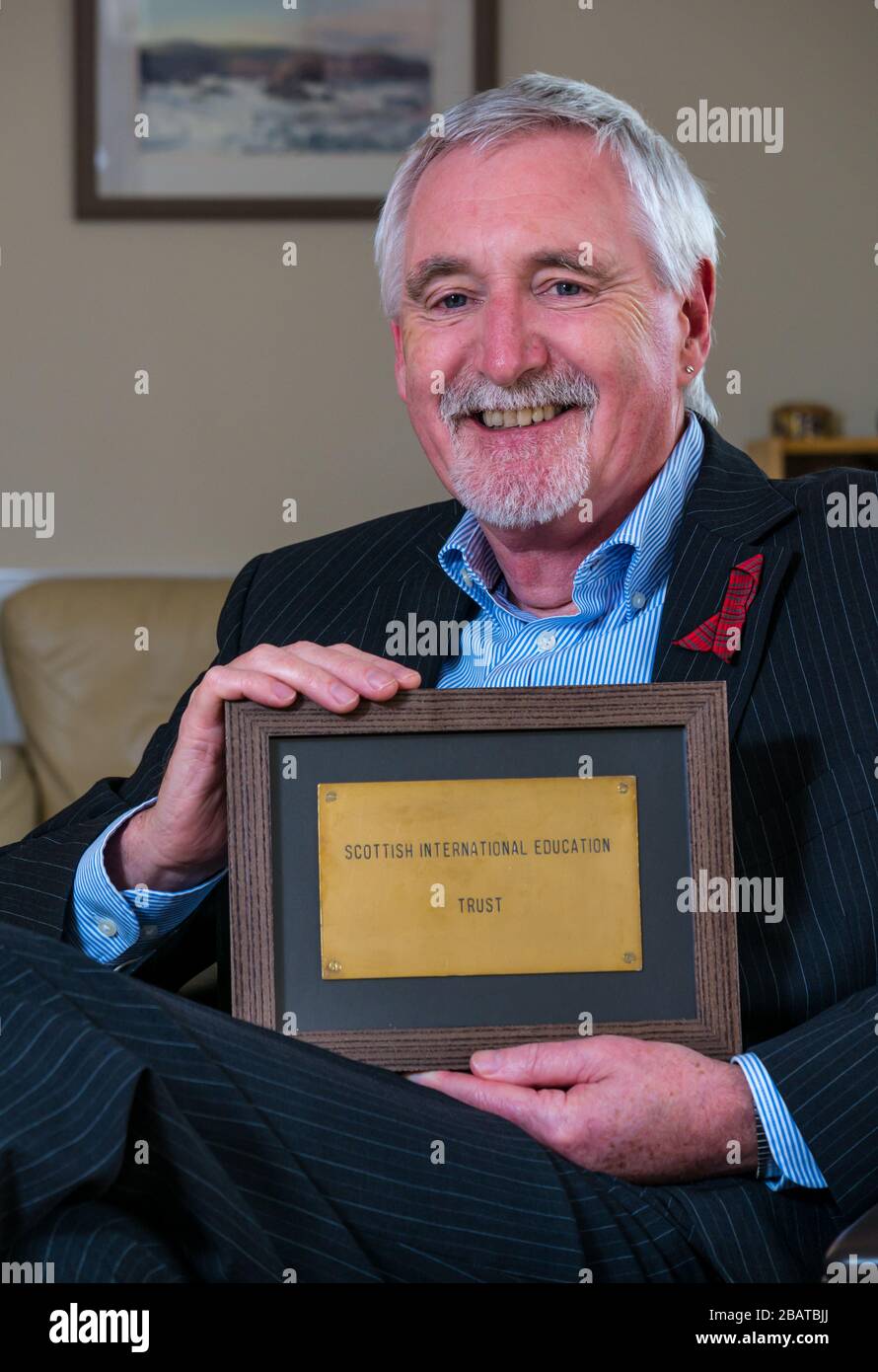 Il Dr Mike Ewart, direttore della Scottish International Education Trust fondata da Sir Sean Connery, detiene la targa della porta d'ufficio di SIET, Scozia, Regno Unito Foto Stock