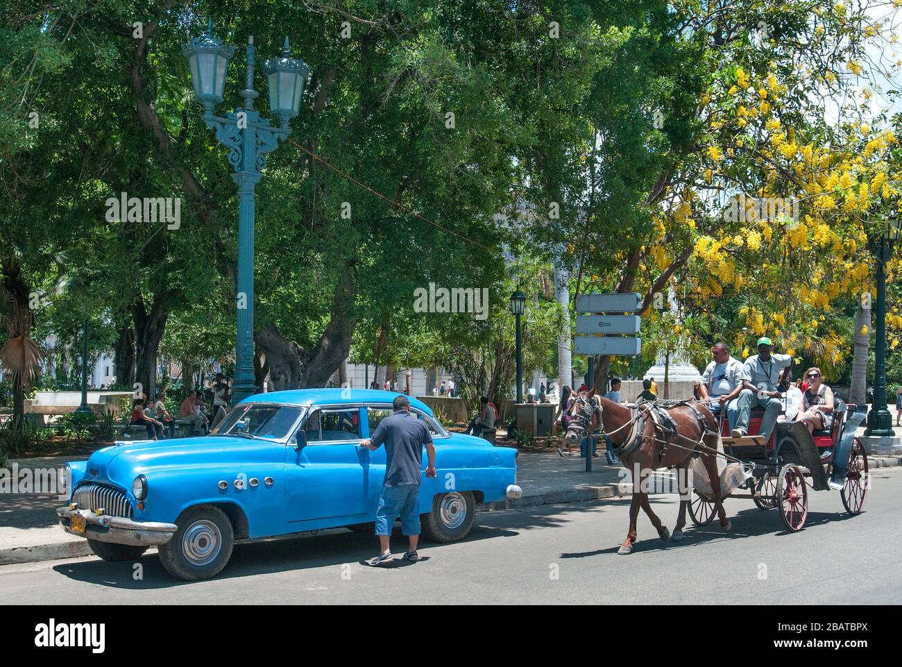 Auto d'epoca e carrozza a cavallo con i turisti al Parque Central, l'Avana, Cuba Foto Stock